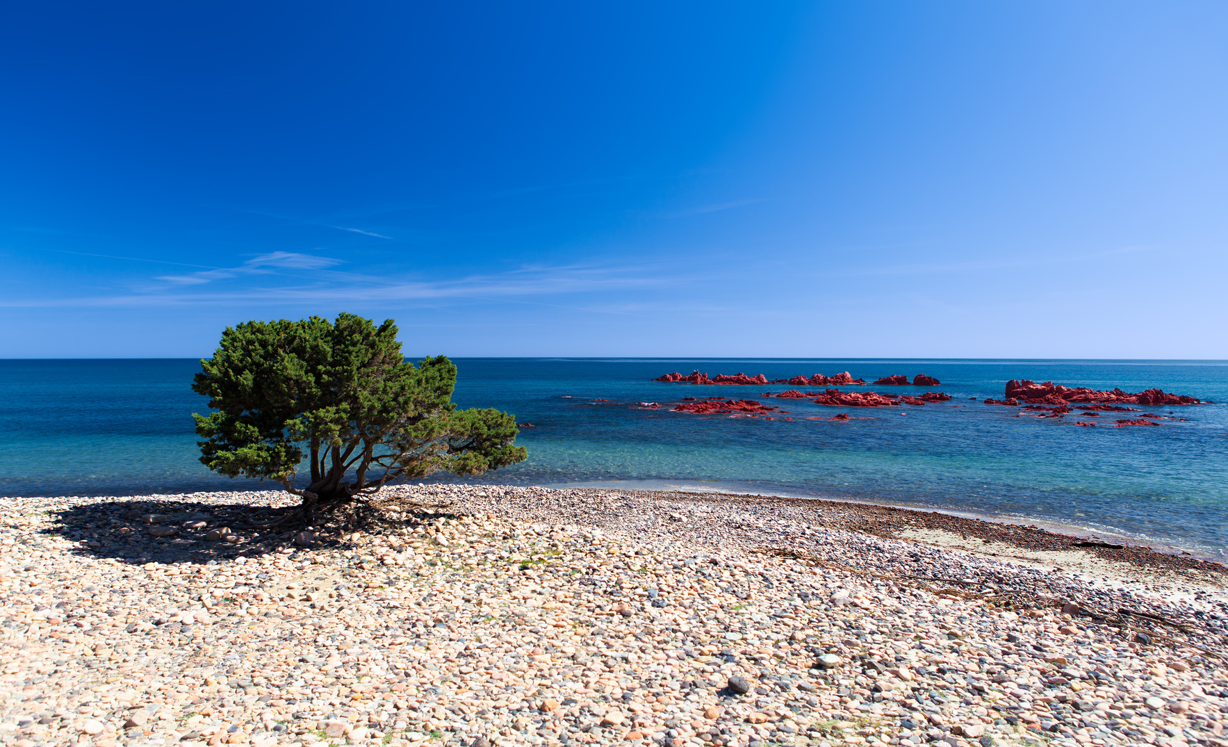 Playa Baccu e Praidas con los escollos de pórfido rojo