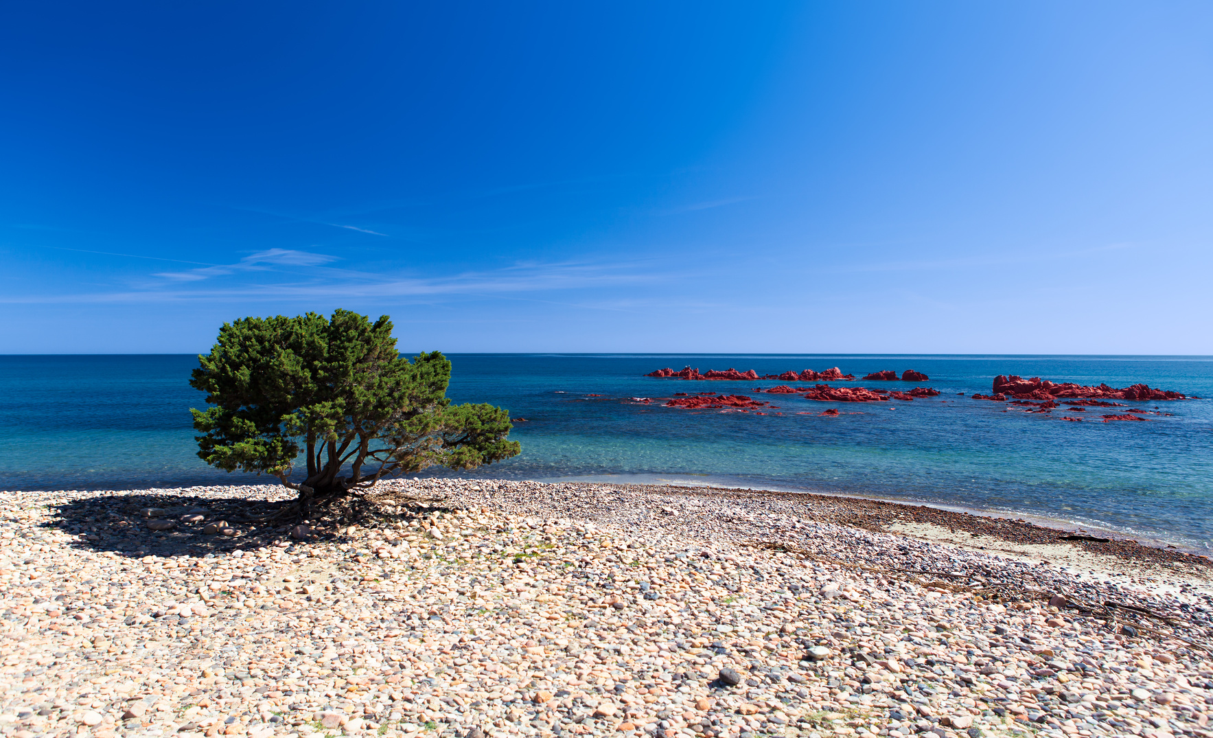 Beach of Baccu de Praidas with the red porphyry cliffs