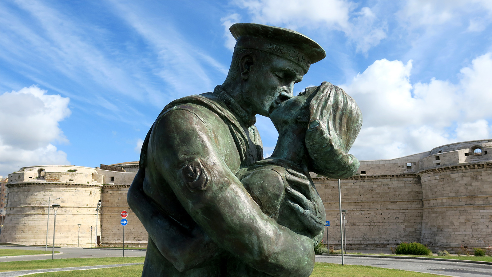 The statue “Kissing in Memory of a Port” in the foreground.